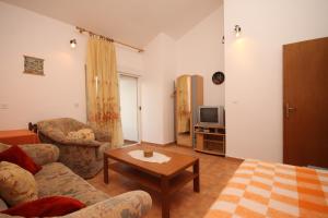uma sala de estar com um sofá e uma mesa em Apartments by the sea Razanj, Rogoznica - 7517 em Rogoznica