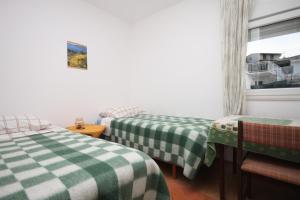 um quarto com duas camas com lençóis verdes e brancos em Apartments by the sea Razanj, Rogoznica - 7517 em Rogoznica