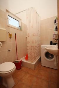 a bathroom with a toilet sink and a shower curtain at Apartments by the sea Razanj, Rogoznica - 7517 in Rogoznica