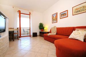 a living room with a red couch and a television at Apartments with a parking space Ravni, Labin - 7450 in Ravni
