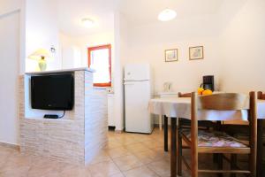 a kitchen and dining room with a tv and a table at Apartments with a parking space Ravni, Labin - 7450 in Ravni