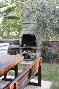 a stone oven with a picnic table and a bench at Apartments with a parking space Funtana, Porec - 7414 in Funtana