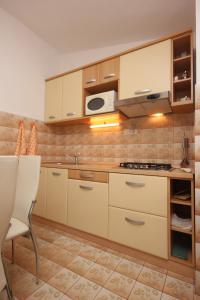 a kitchen with white cabinets and a stove top oven at Apartments with a parking space Funtana, Porec - 7414 in Funtana