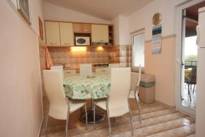 a kitchen with a table and chairs in a room at Apartments with a parking space Funtana, Porec - 7414 in Funtana