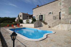 a swimming pool in front of a house at Luxury villa with a swimming pool Skrapi, Central Istria - Sredisnja Istra - 7525 in Brajkovići