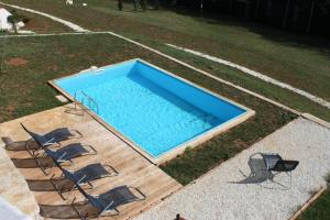 a swimming pool with four chairs and a table at Family friendly house with a swimming pool Skrapi, Central Istria - Sredisnja Istra - 7526 in Brajkovići