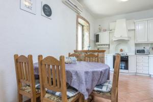 a kitchen with a table with a purple table cloth at Seaside holiday house Plomin Luka, Labin - 7466 in Plomin