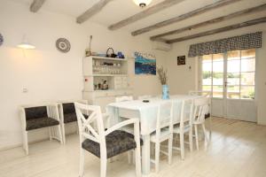 a white dining room with a white table and chairs at Family friendly house with a swimming pool Skrapi, Central Istria - Sredisnja Istra - 7526 in Brajkovići