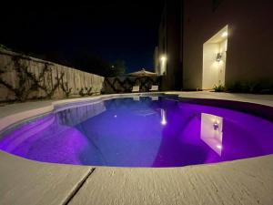 a swimming pool with purple lighting at night at Luxury Home w/ Private Saltwater Pool in Midtown in Houston