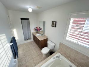 a bathroom with a toilet and a sink and a tub at Beautiful Vacation Home near Toronto Airport in Mississauga