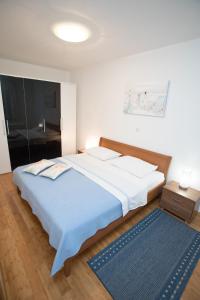 Un dormitorio con una cama grande y una alfombra azul en Apartments by the sea Razanj, Rogoznica - 7484 en Ražanj