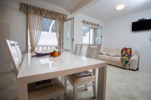 a kitchen and living room with a white table and chairs at Apartments by the sea Razanj, Rogoznica - 7484 in Ražanj