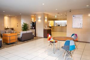 a waiting area with a table and chairs in a lobby at Court Hotel Mito in Mito +27 photos