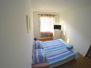 a small bedroom with a bed and a television at Apartments with a parking space Biograd na Moru, Biograd - 6201 in Biograd na Moru