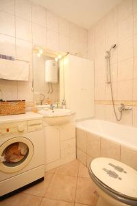 a bathroom with a toilet sink and a washing machine at Apartments with WiFi Split - 7563 in Split