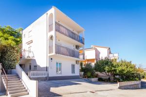 a white building with stairs in front of it at Apartment Arbanija 7543a in Trogir