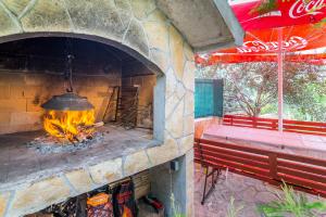 a brick oven with a fire in it next to a bench at Apartment Arbanija 7543a in Trogir