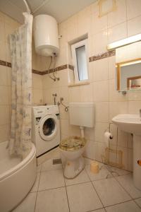 a bathroom with a toilet and a washing machine at Apartments by the sea Slatine, Ciovo - 7544 in Slatine