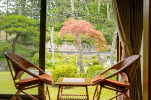 two chairs and a table in front of a window at Hotel Hagoromo in Shizuoka