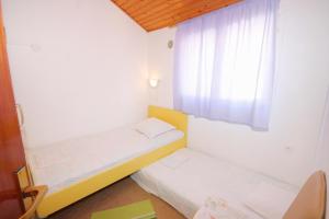 a small room with two beds and a window at Apartments with a parking space Vela Luka, Korcula - 7551 in Vela Luka