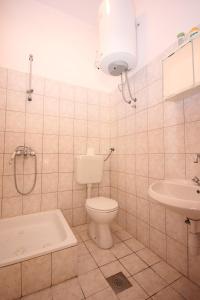 ein Badezimmer mit Toilette, Waschbecken und Dusche in der Unterkunft Apartments with a parking space Podstrana, Split - 7572 in Podstrana