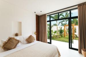 a bedroom with a large bed and a large window at Villa Lamer Canggu in Canggu