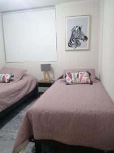 a bedroom with a bed with a zebra picture on the wall at Departamento en La Serena in La Serena