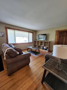 a living room with a couch and a table at Feel at home, Country style family house. in Magrath