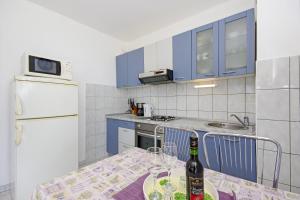 a kitchen with a table with a bottle of wine at Apartments by the sea Split - 7589 in Split
