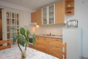 a kitchen with a table and a white refrigerator at Apartments by the sea Brna, Korcula - 7553 in Smokvica