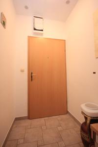 bagno con porta in legno e servizi igienici. di Apartments by the sea Omis - 7577 a Omiš (Almissa) Altre 11 foto