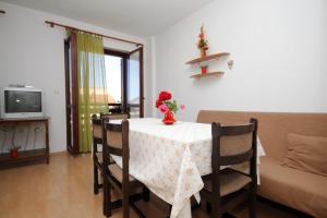 a dining room table with a vase of flowers on it at Apartments with a parking space Peroj, Fazana - 7516 in Vodnjan