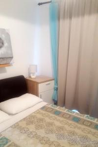 a small bedroom with a bed and a curtain at Apartments with a parking space Novi Vinodolski - 7503 in Novi Vinodolski