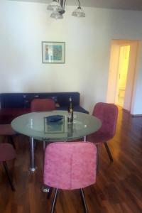 une table à manger avec des chaises roses et une table dans l'établissement Apartments with a parking space Novi Vinodolski - 7503, à Novi Vinodolski