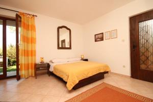 a bedroom with a bed and a mirror at Apartments with a parking space Presika, Labin - 7617 in Labin