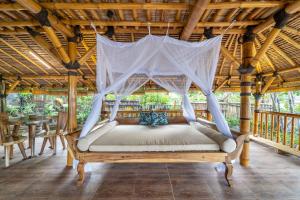 a bed in a pavilion with a mosquito net at Catappa Village Lombok in Sekotong