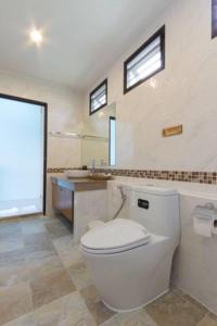 a bathroom with a white toilet and a sink at Moonlight Cottage in Ban Pa Khlok