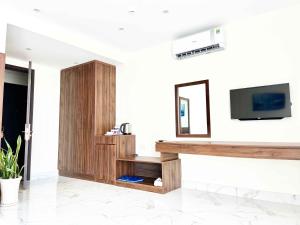 a living room with a tv on a wall at Hoàng Triều Hotel - Marina Bình Dương in Thu Dau Mot +45 photos
