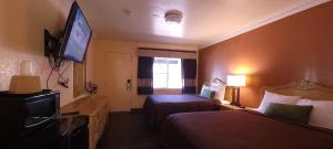 a hotel room with two beds and a flat screen tv at Lakeview Inn in Lucerne