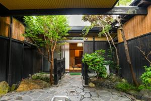 una entrada al jardín de una casa con una valla en Ryokan Yayanoyu en Ueki