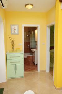 a bathroom with a green cabinet and a yellow wall at Holiday house with a swimming pool Gornja Podgora, Makarska - 5985 in Podgora