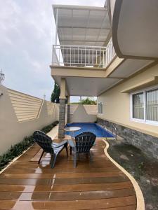 a patio with two chairs and a table and a balcony at Diyar Villas Puncak H8/7 in Puncak