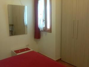 um quarto com uma cama, um espelho e uma janela em Casetta "Anna" em Borgo Celano