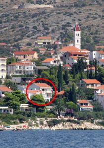 a red house in the middle of a city at Apartments by the sea Seget Vranjica, Trogir - 5964 in Seget Vranjica