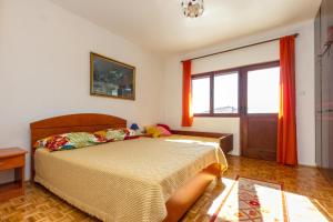 a bedroom with a bed and a window at Apartments by the sea Seget Vranjica, Trogir - 5964 in Seget Vranjica