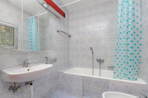 a bathroom with a sink and a bath tub at Apartments by the sea Seget Vranjica, Trogir - 5964 in Seget Vranjica
