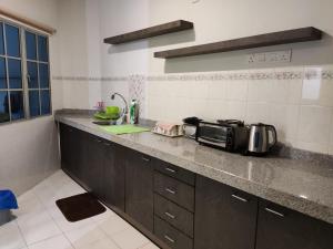 a kitchen with a counter top with a microwave at Homestay 116 in Ipoh