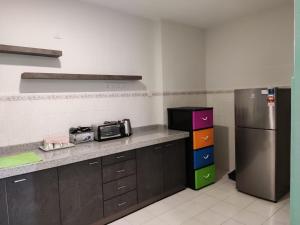 a kitchen with a refrigerator and a counter top at Homestay 116 in Ipoh