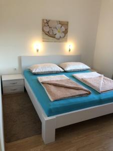 a bed with two pillows on it in a bedroom at Apartments with parking space Rab - 12383 in Rab