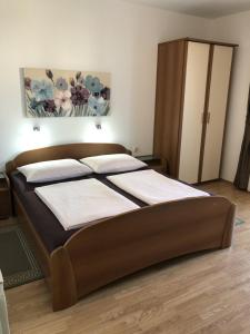 a bedroom with a large bed with a wooden headboard at Apartments with parking space Rab - 12383 in Rab